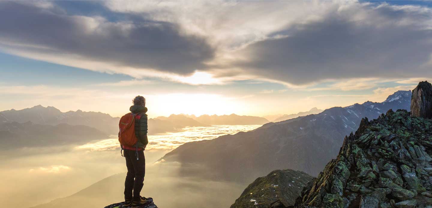 Walker with red rucksack overlooking mountains. Walker with red rucksack overlooking mountains.