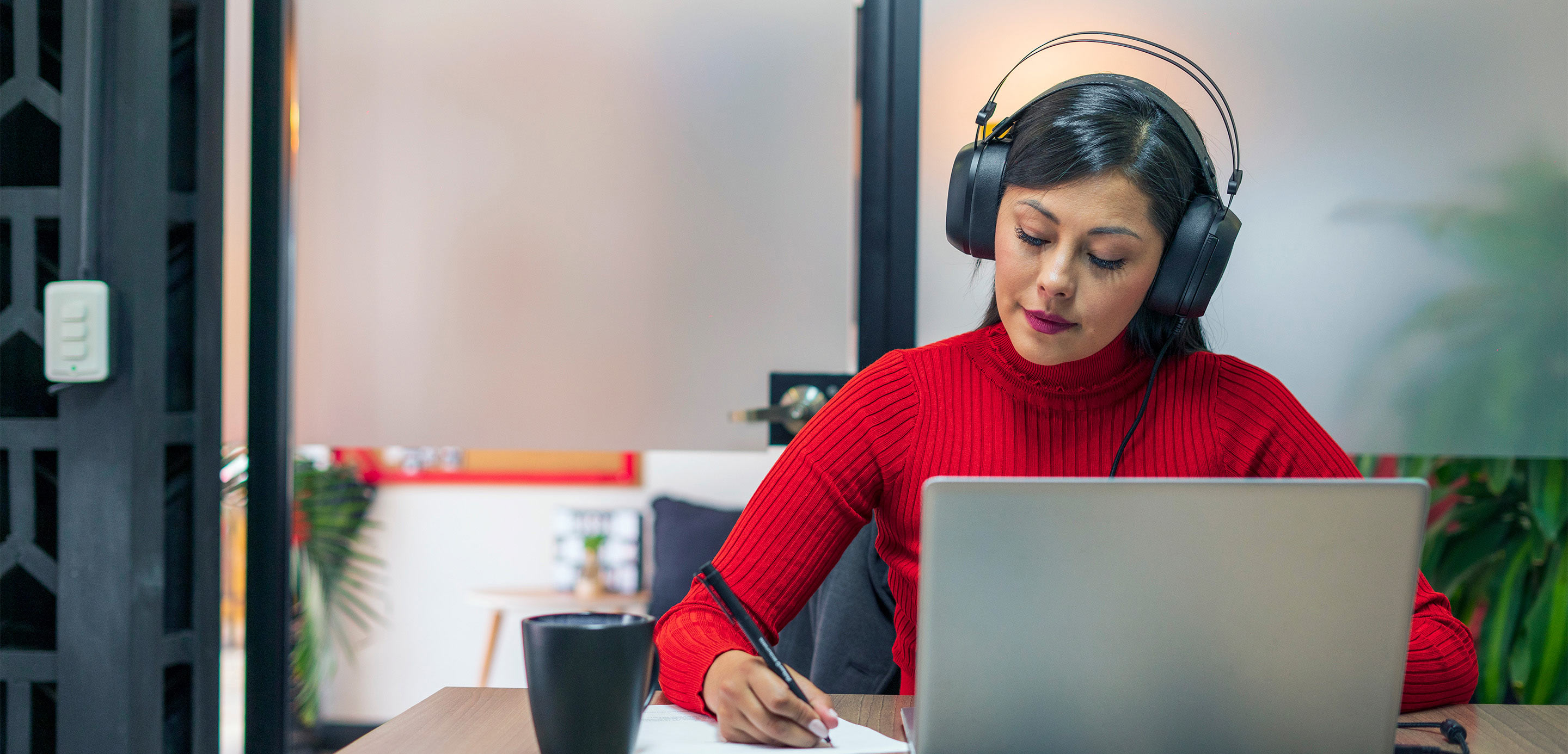 Lady with headphones working at laptop