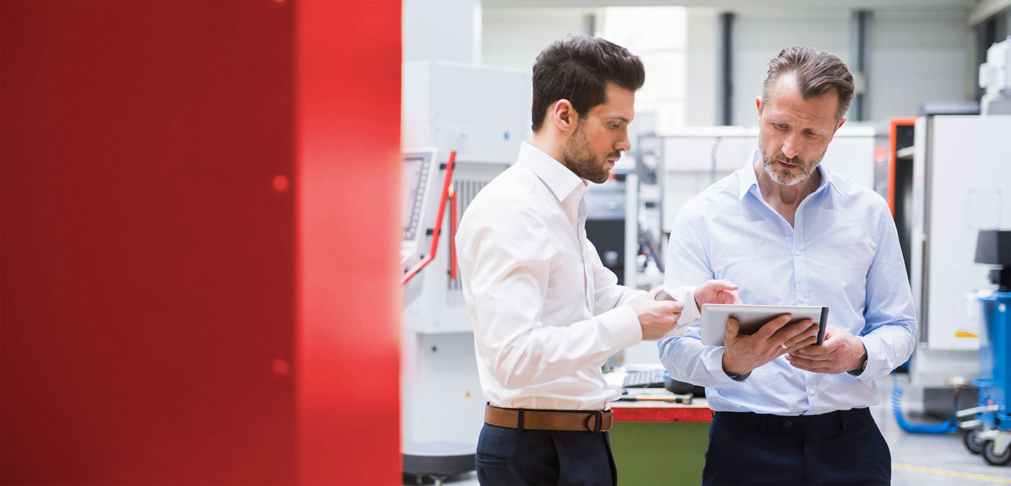 Two gentlemen looking at a report on a tablet Two gentlemen looking at a report on a tablet